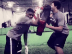 Defensive lineman practicing swim move on football practice dummy