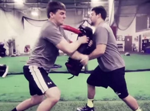 High school players practice fighting off blocks using The Colt blocking pad