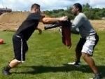 Adult football players practice rip move using Krausko training dummy