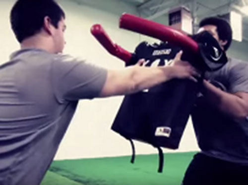 Offensive and defensive linemen practice hand placement on Krausko football blocking pad